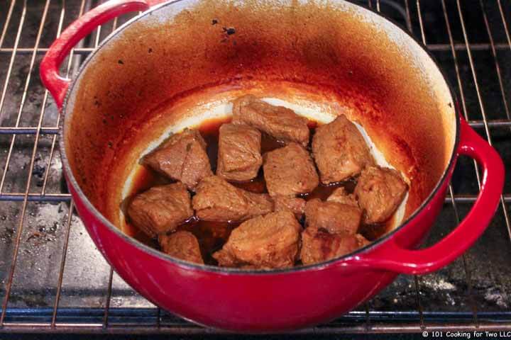 cooked pork in Dutch oven uncoverd in oven.