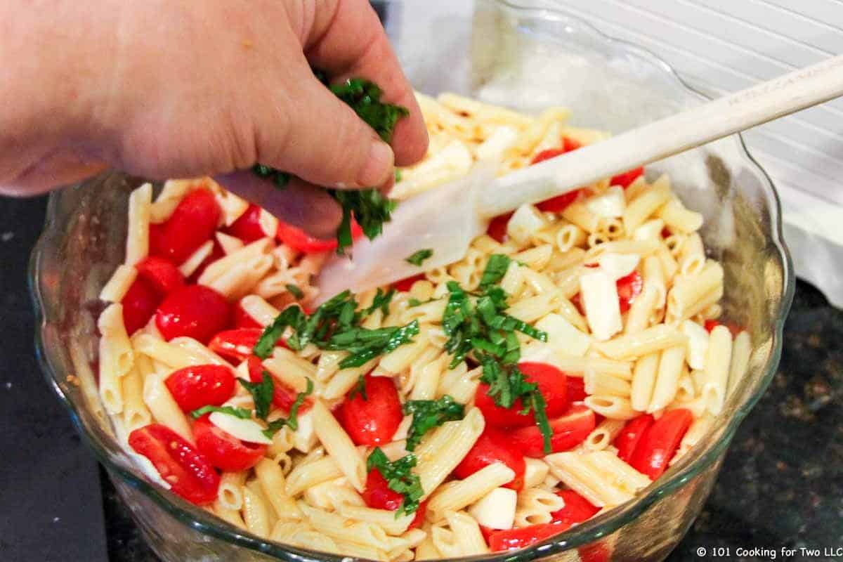 Adding basil to the caprese.