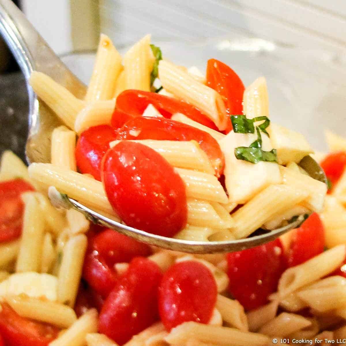 Caprese Pasta salad on a large spoon.