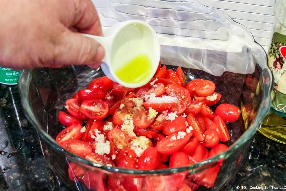 adding oil to caprese salad.