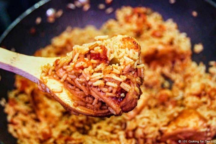 rice and chicken on large spoon over pan