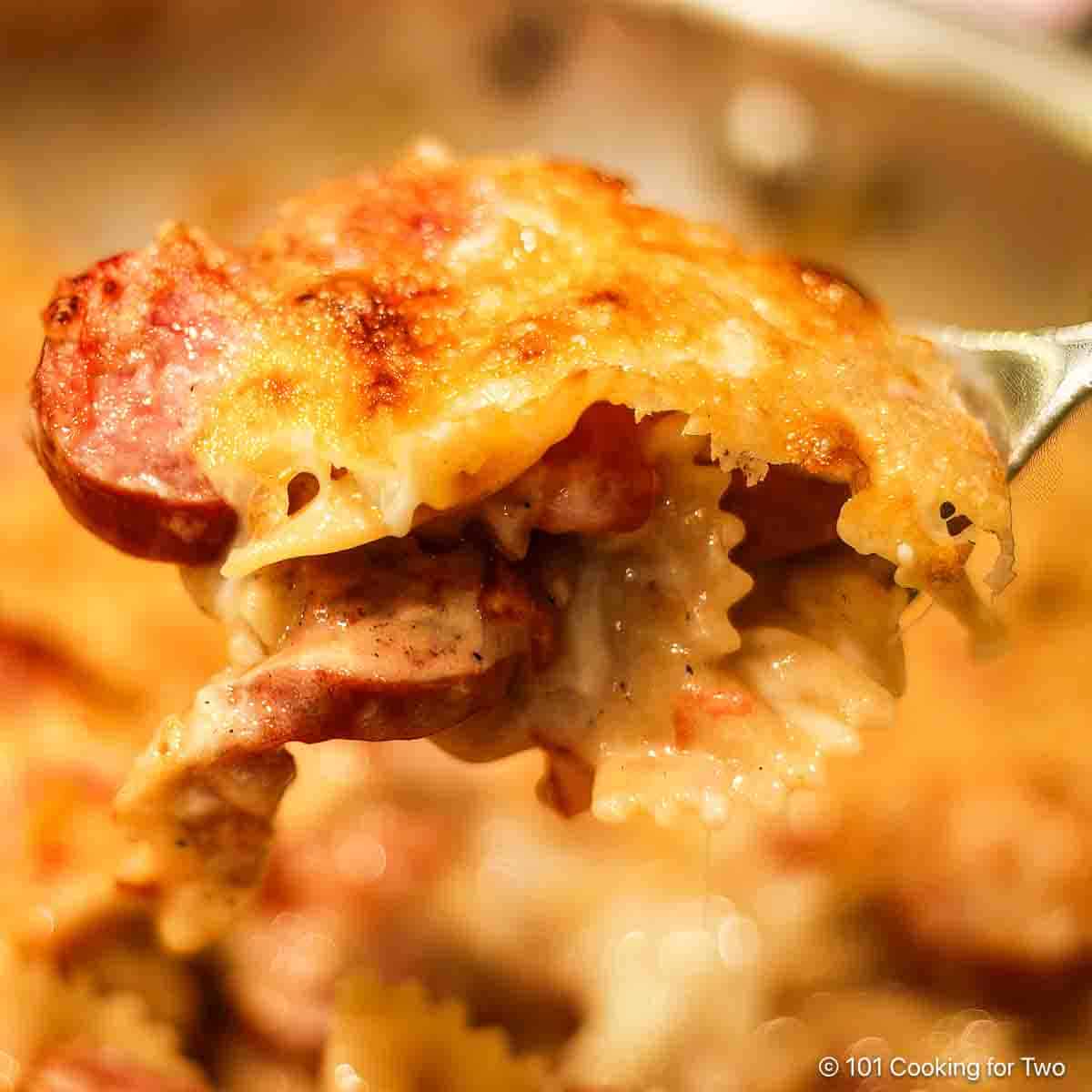 spicy smoked sausage pasta on a fork.