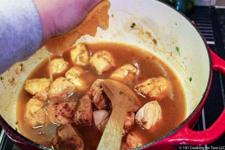 adding orange to chicken.