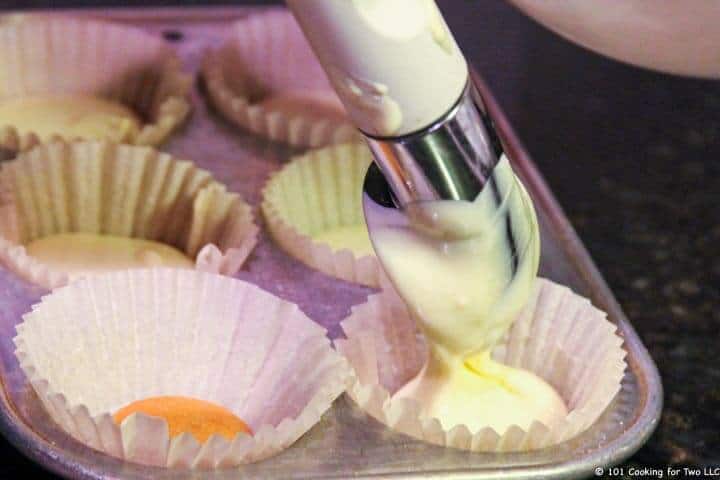 adding batter to cupcake papers