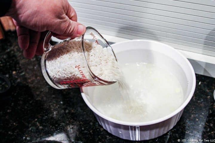 adding rice to bowl with water