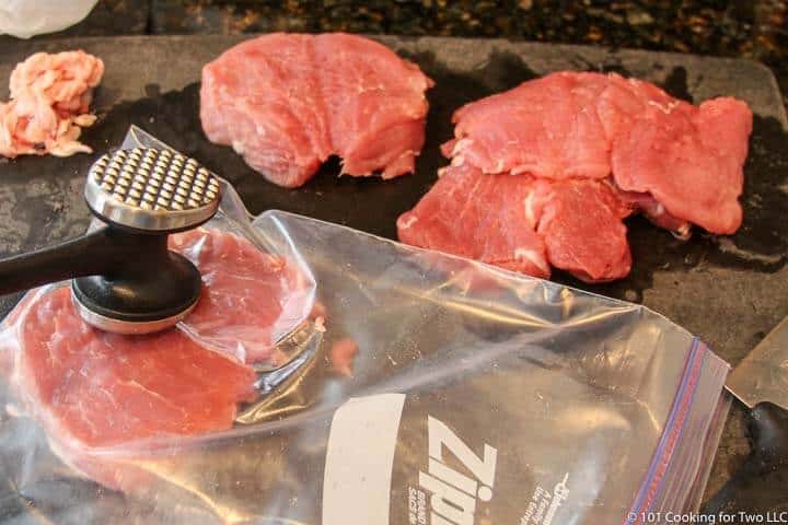 flattening the pork with meat mallet.