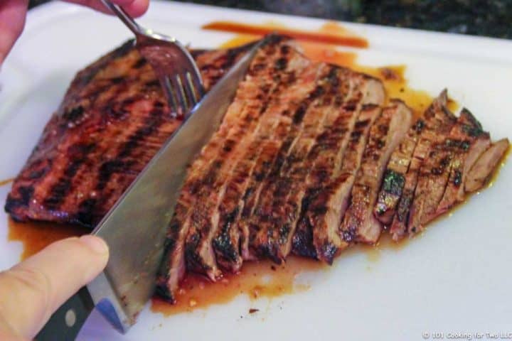 cutting flank steak across grain on white board