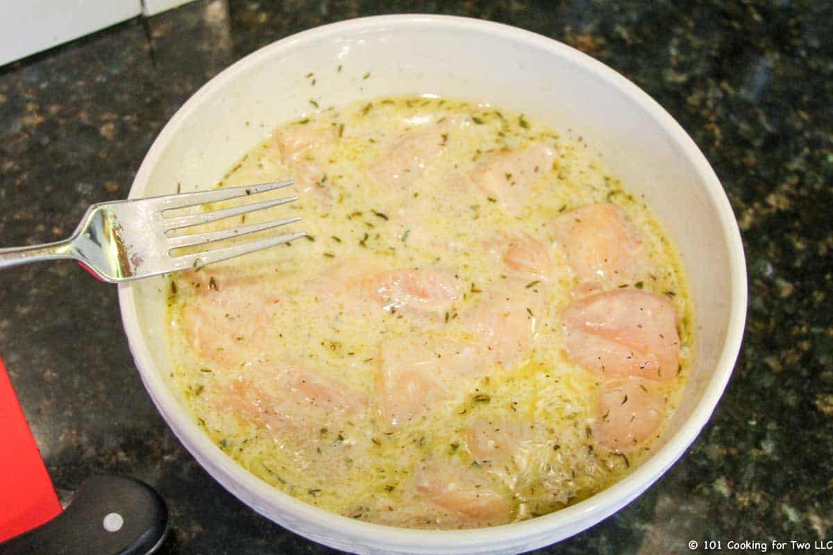 marinade in bowl with chicken cubes.