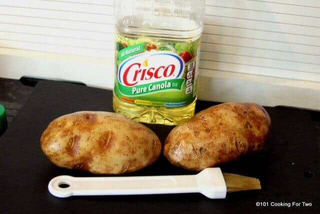Grilled baked potatoes picture of two large potatoes and some oil