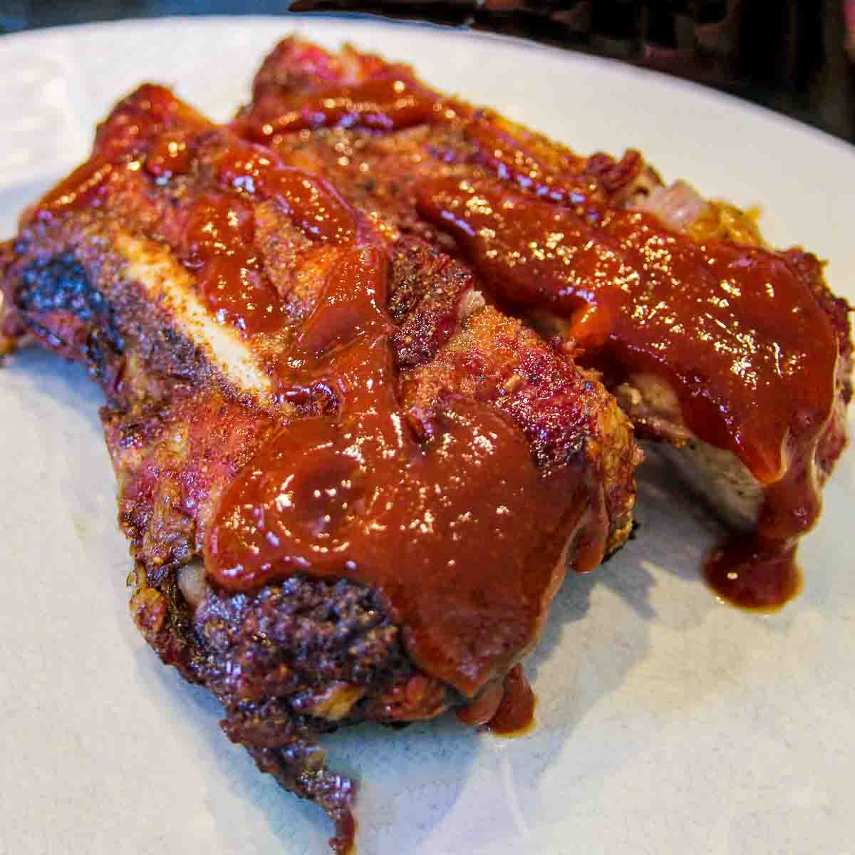 Ribs with sauce on white plate.