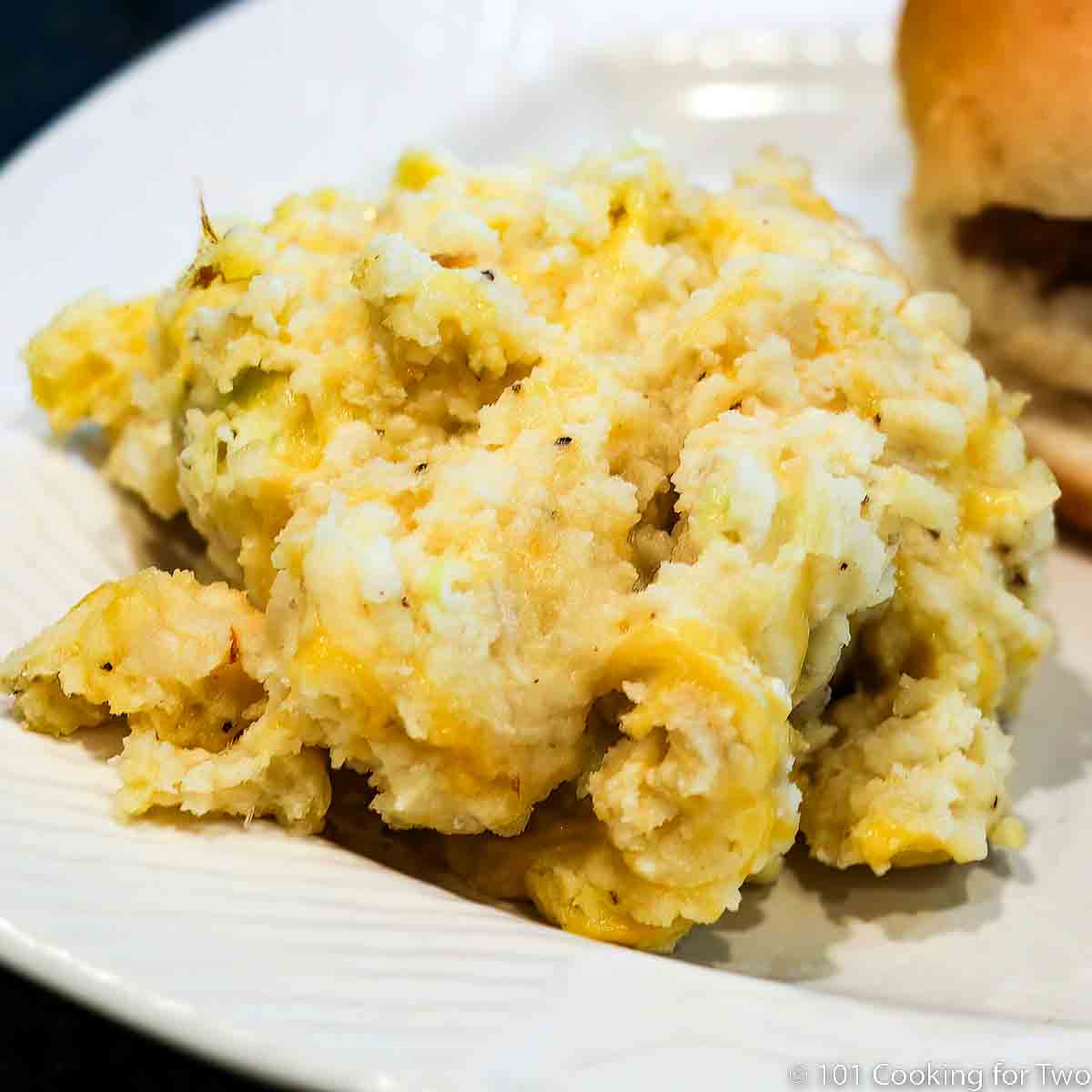 chessy potatoes on a white plate.