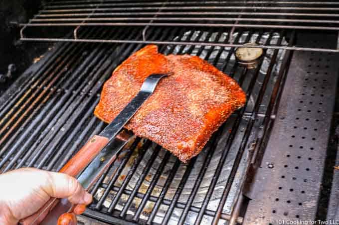 placing brisket on the grill