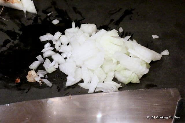 image of a chopped onion on a black cutting board.