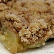 close up of a spice of apple crisp on a white plate