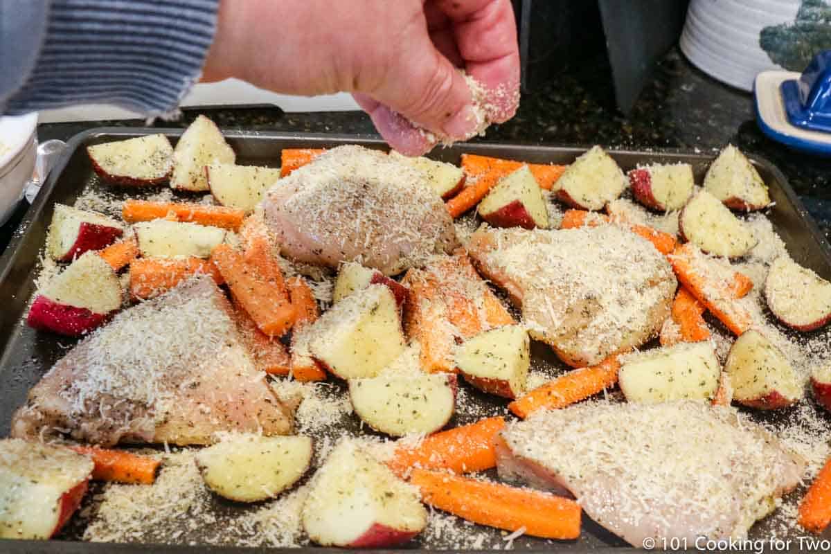 coating the chicken and veggies with cheese