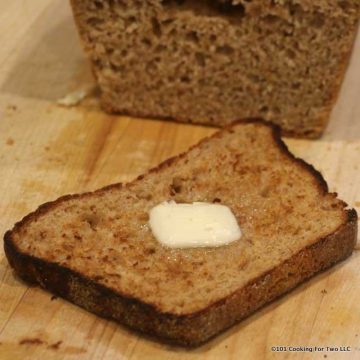 a slice of Honey Whole Wheat English Muffin Bread with butter