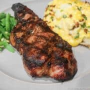 a strip steak with grill marks on a gray plate