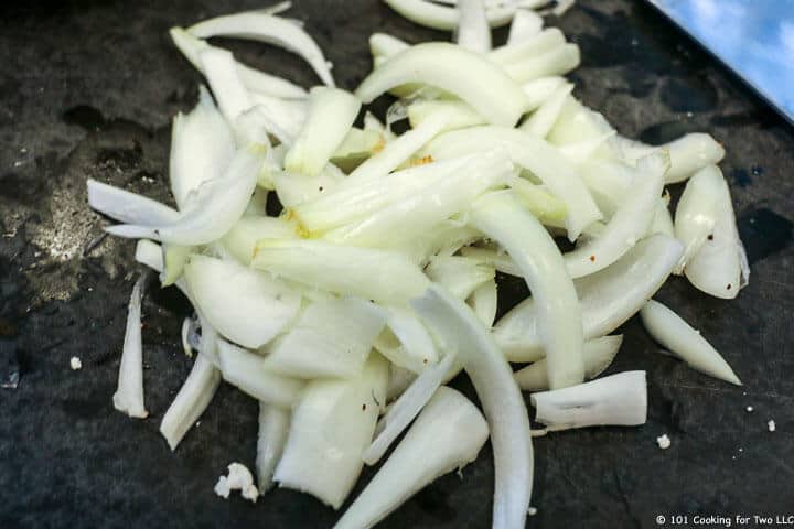 chop an onion into strips on black board