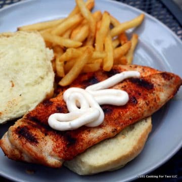 Grilled Blackened Chicken Sandwich on a gray plate with fries