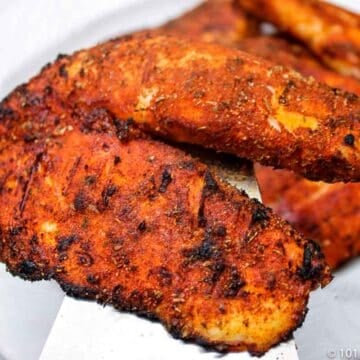 A pile of blackened tilapia on a white plate.