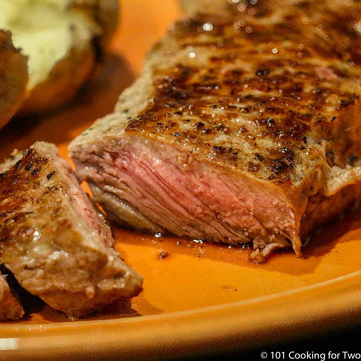 photo closeup of a nicely done strip steak cut showing medium rare