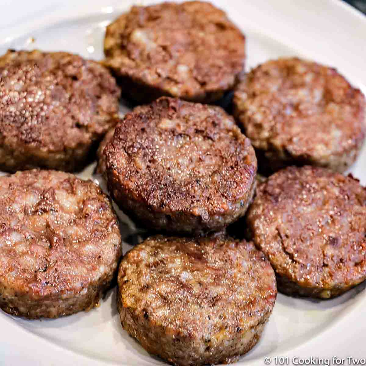 Close up image of a well done round piece of breakfast sausage on a pile of others