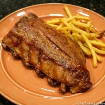 baby back ribs on an orange plate with fries