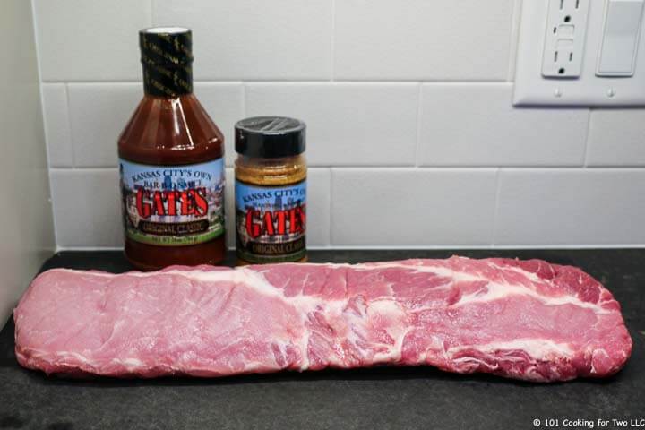 a slab of baby back ribs with rub and sauce