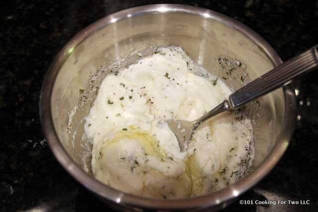 image of mixing ricotta cheese with egg in a metal bowl
