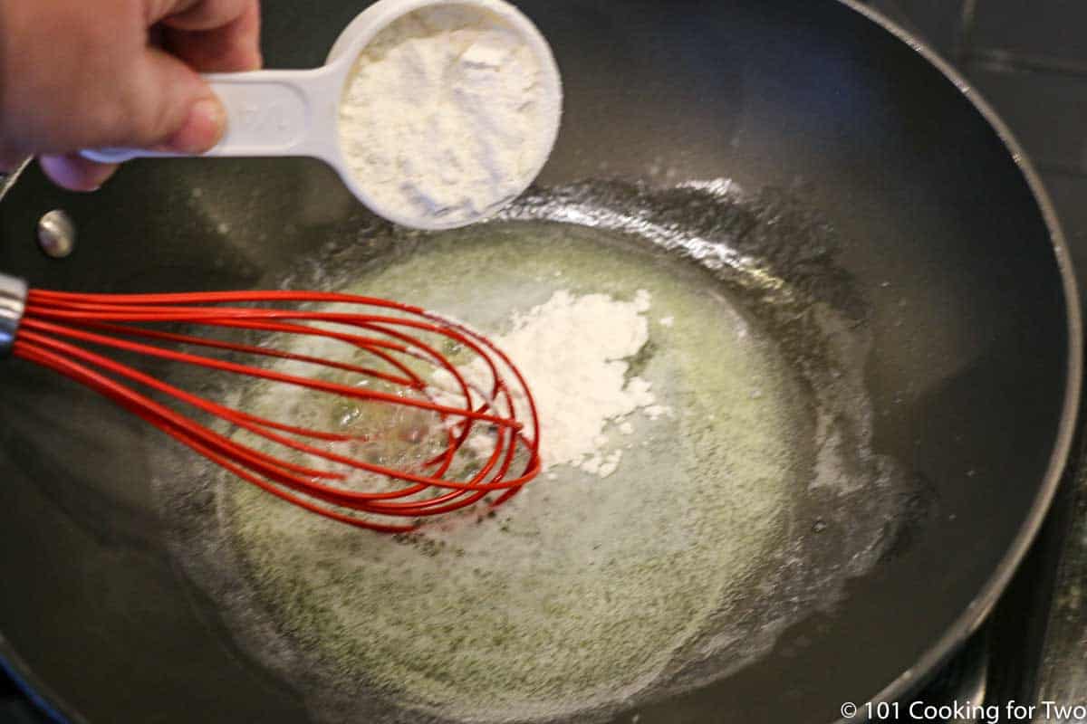 adding flour to melted butter in skillet.
