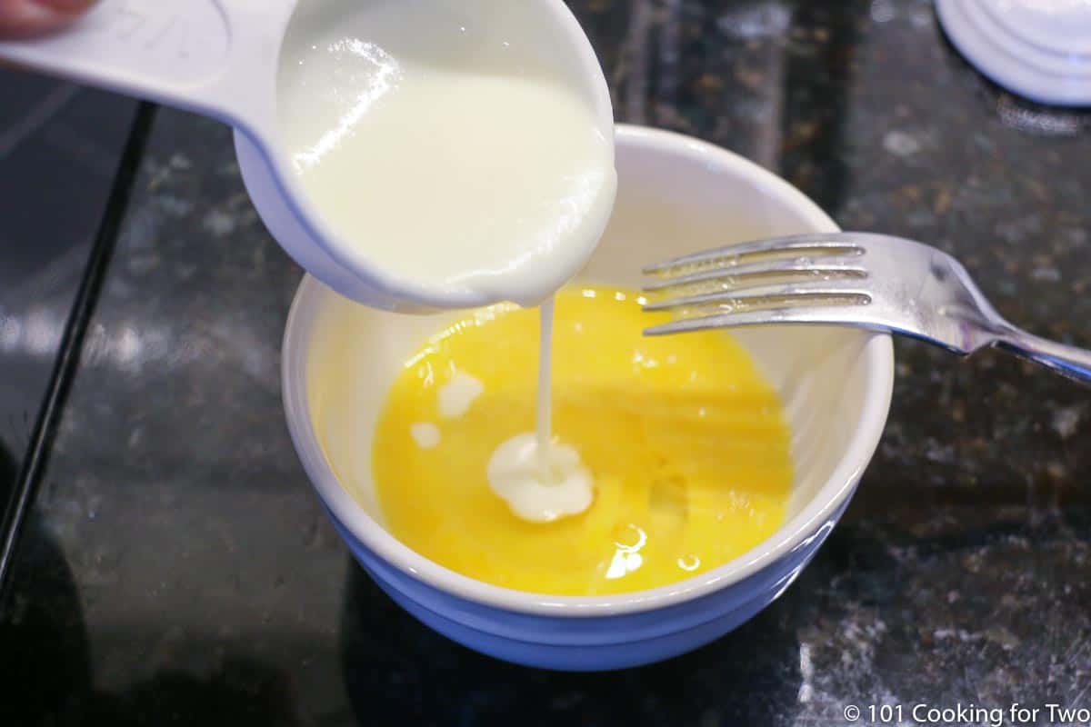 adding hot liquid to beaten egg in small bowl.