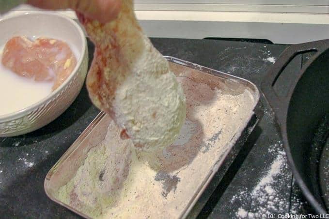 Image of shaking extra flour off chicken
