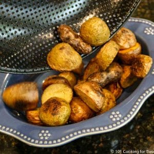 grilled baby potatoes going into a blue bowl