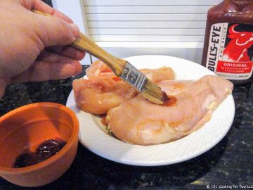 Brushing chicken with BBQ sauce on plate