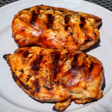 Picture of two Grilled BBQ Skinless Boneless Chicken Breasts on a white plate