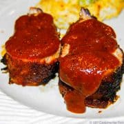 image of slices of pork tenderloin with sauce on white plate