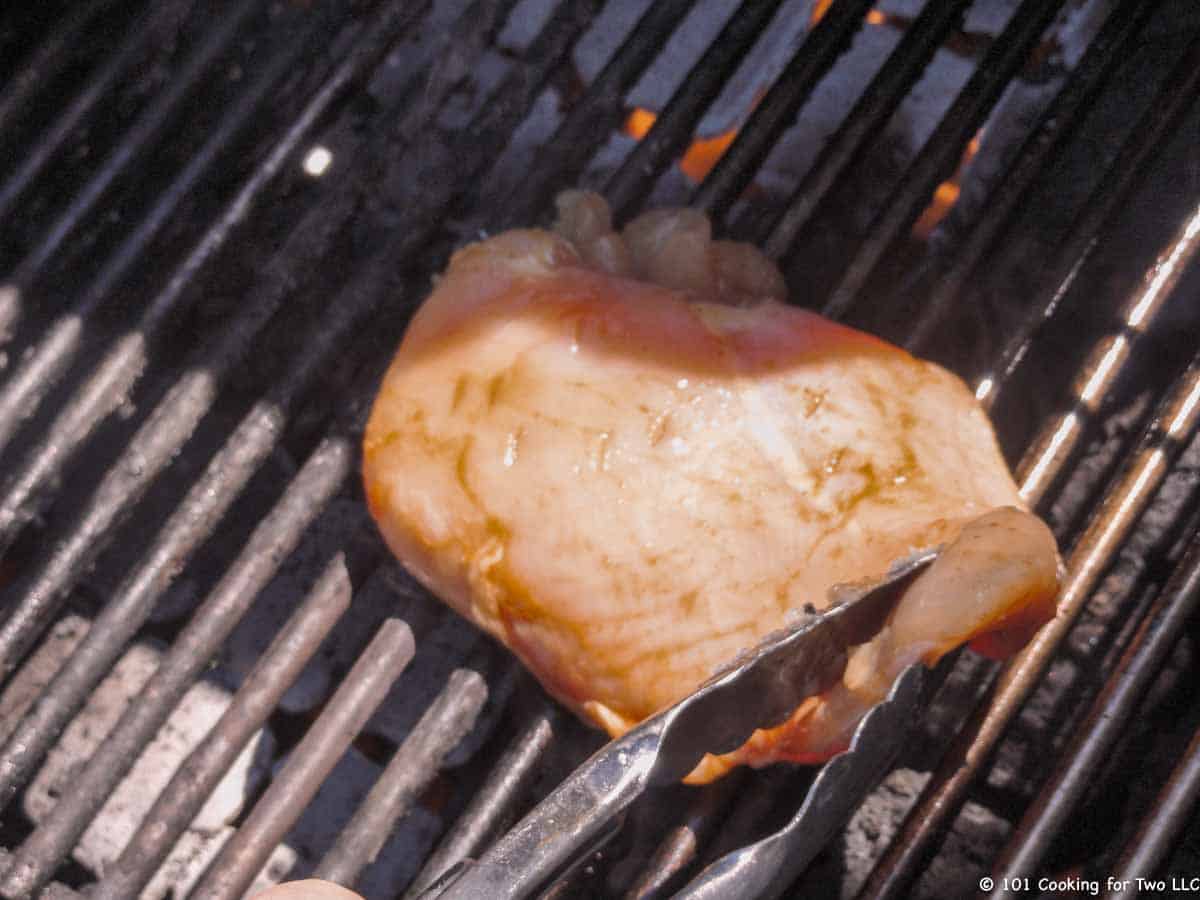 placing chicken breast over direct heat on grill.