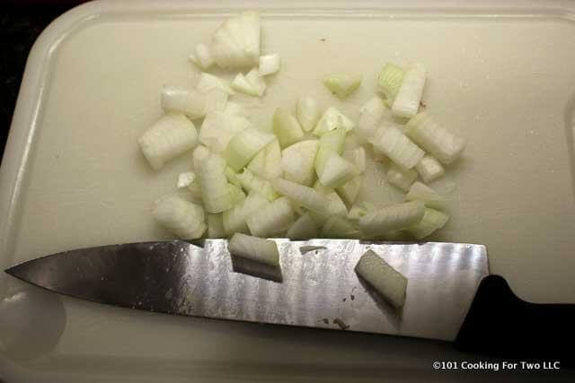image of chopping onions on a white chopping board