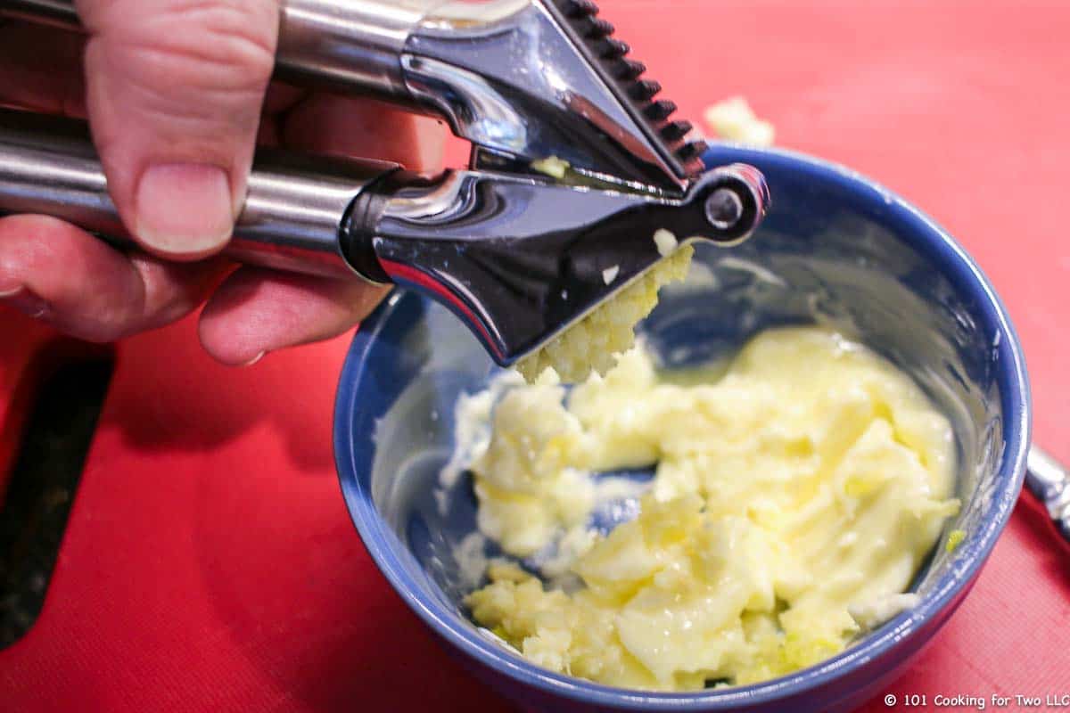 crushing garlic into butter