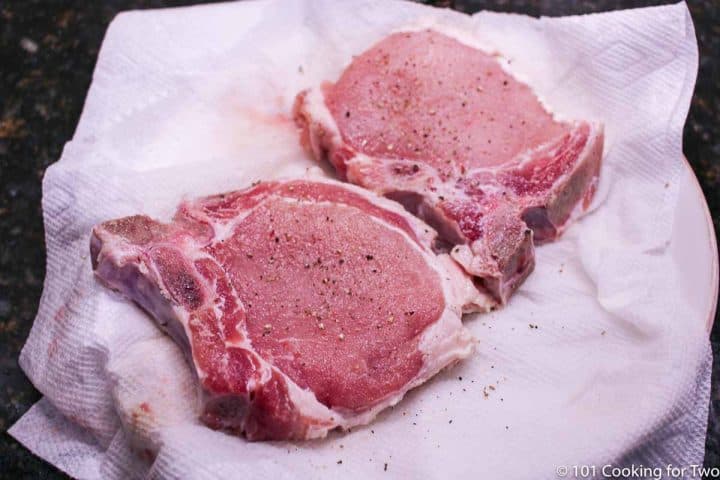 pork chops on paper towels with pepper