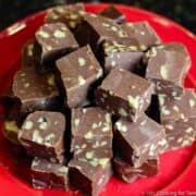 image of a pile of pieces of fudge with nuts on a red plate