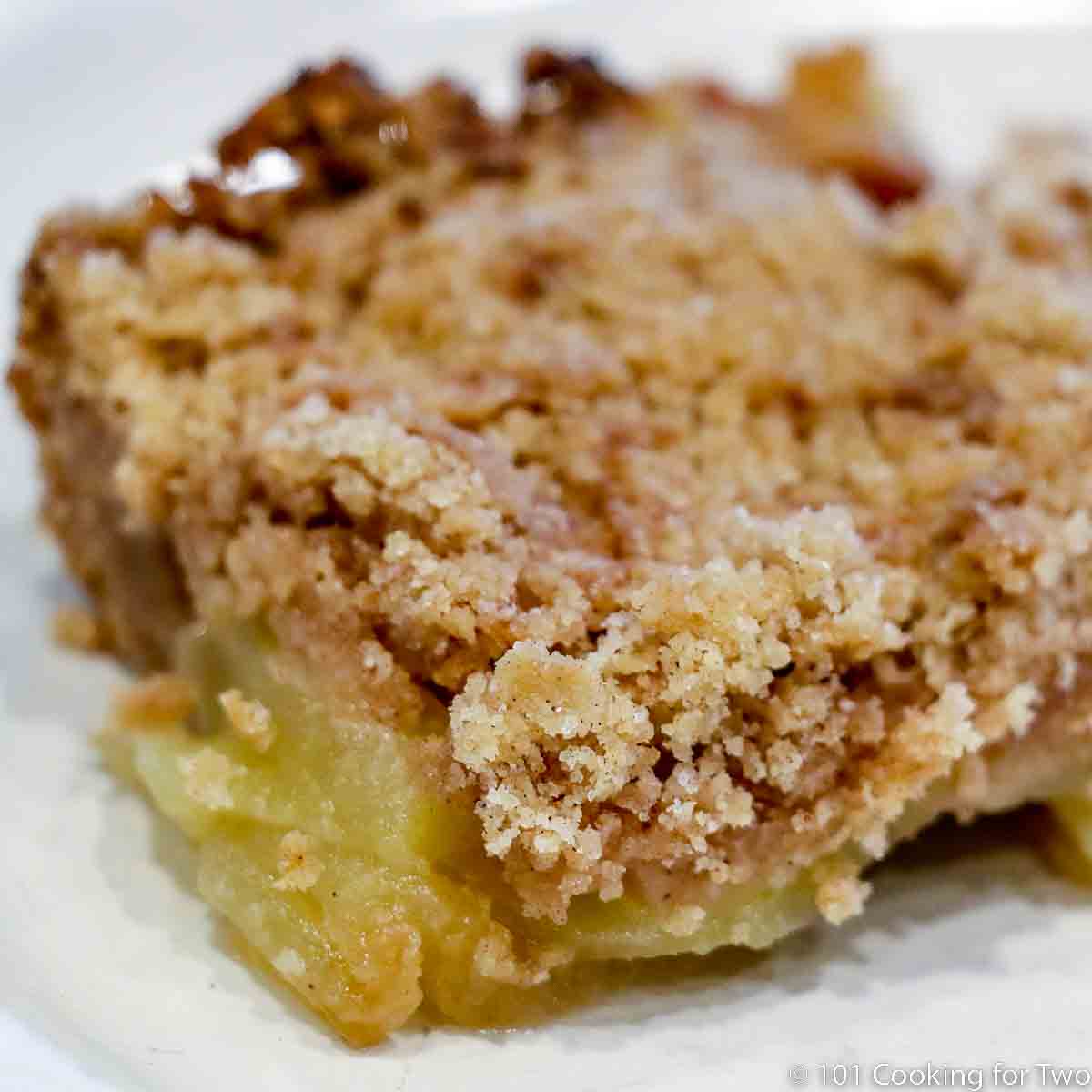close up of a spice of apple crisp on a white plate