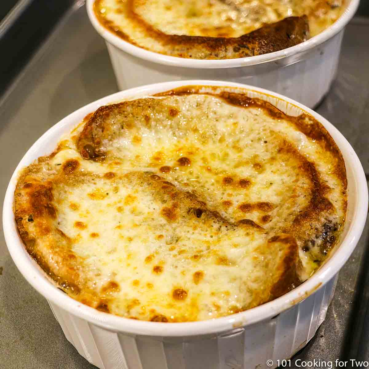 bowl of onion soup covered with browned cheese.