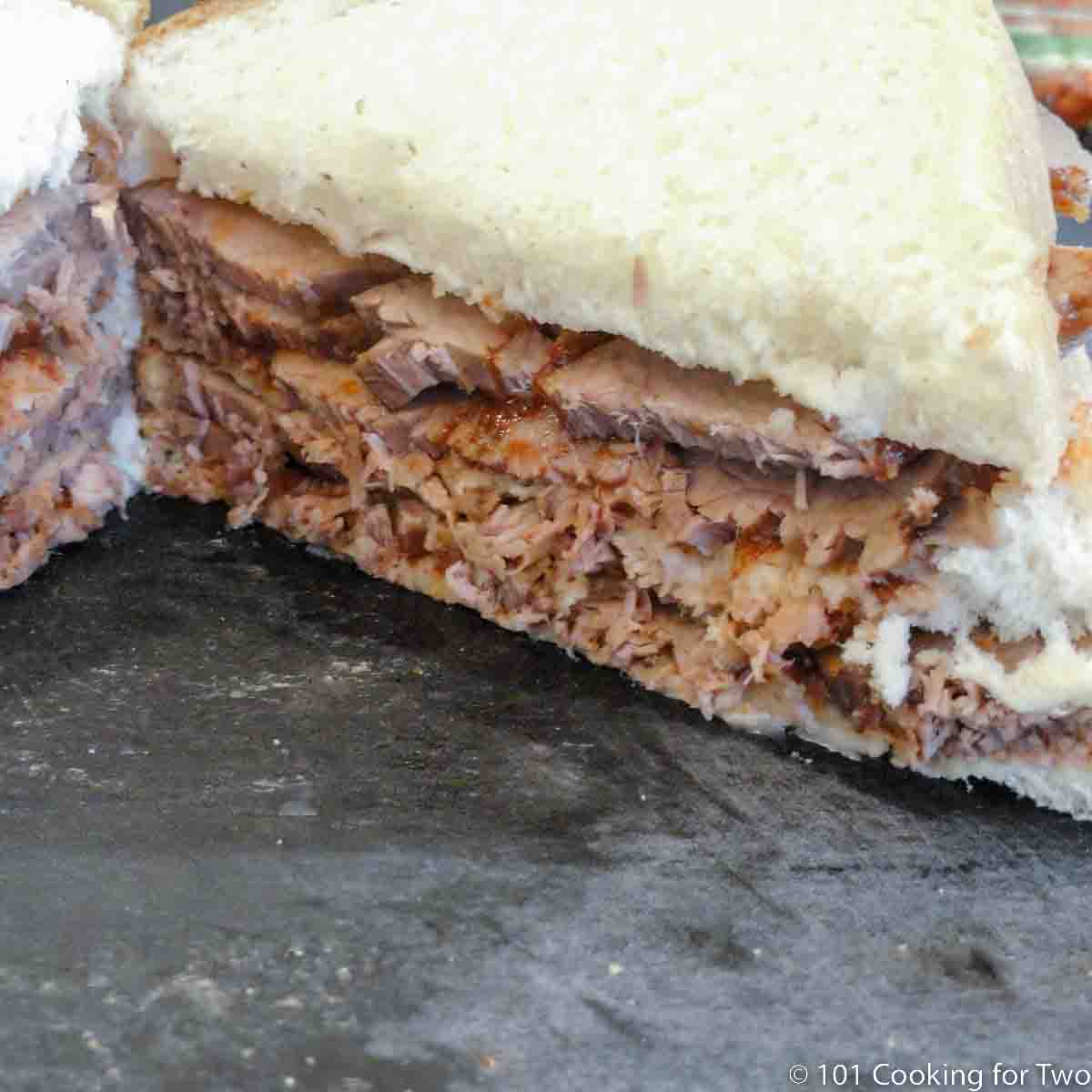 Brisket triple decker sandwich on a black board