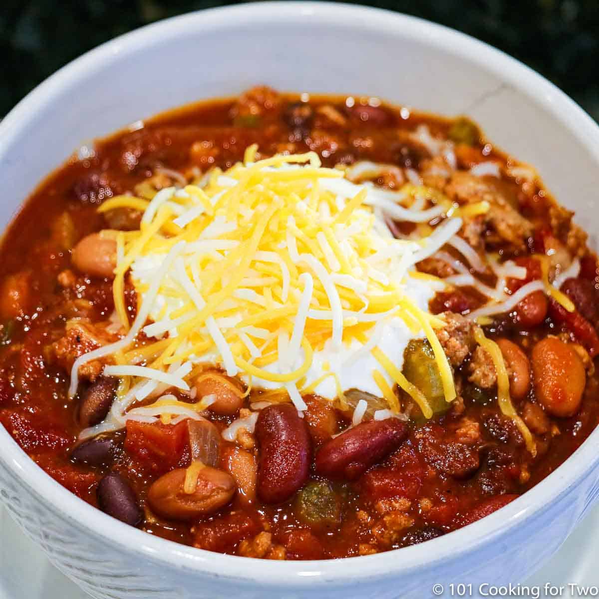 bowl of turkey chili topped with sour cream and cheese