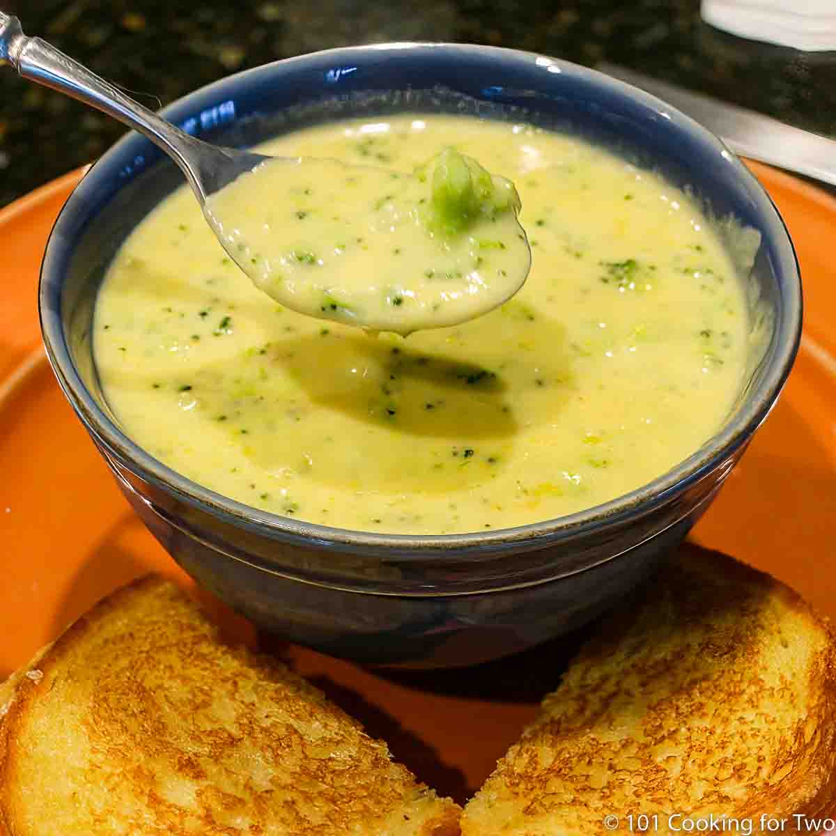 broccoli cheese soup in blue bowl.