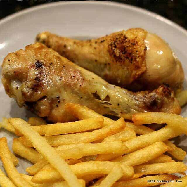 image of drumsticks with French fries on a light gray plate