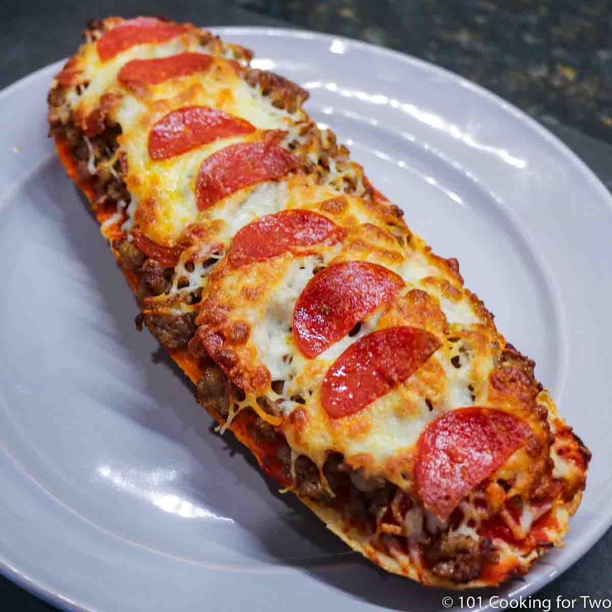 French bread pizza on a gray plate.