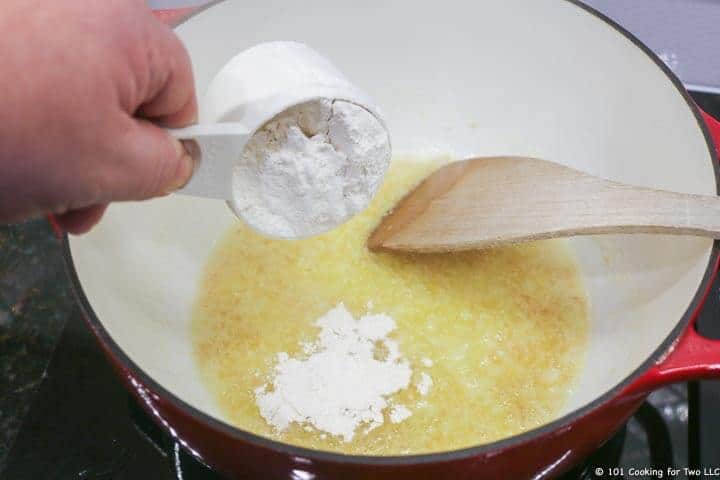 adding flour to pan with butter and onion