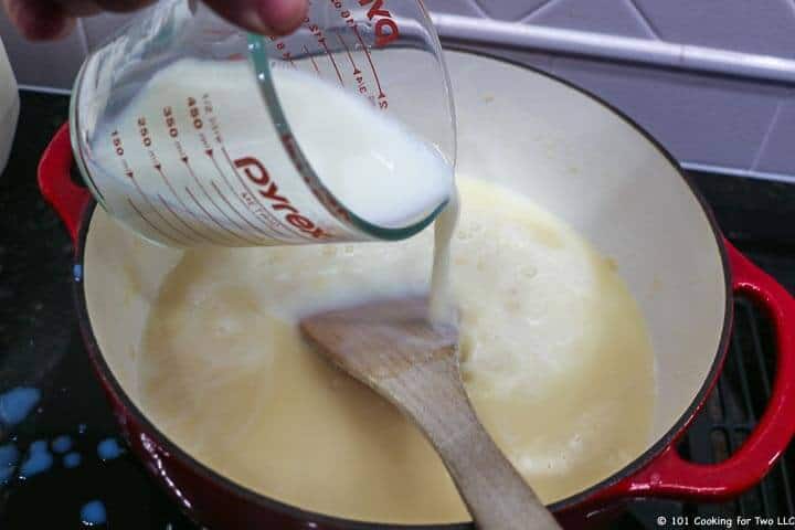 adding milk to soup pot